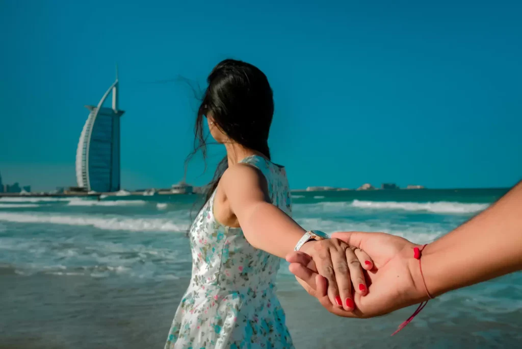 Bride and groom holding hands on Jumeirah Beach