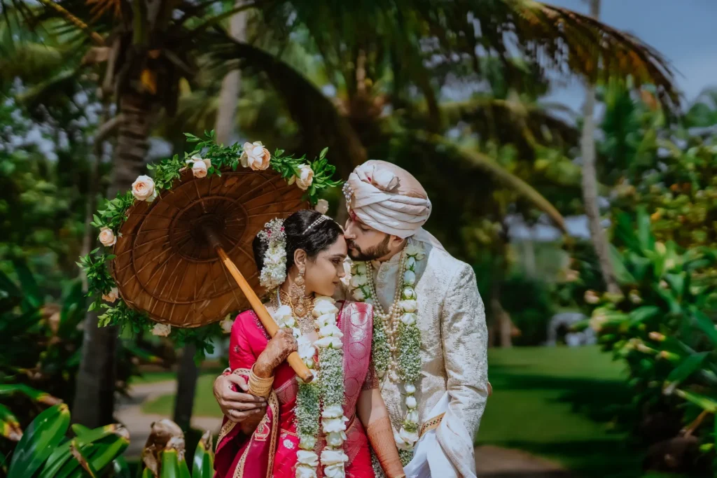 Traditional wedding couple posing in front of the ocean at Taj Kovalam