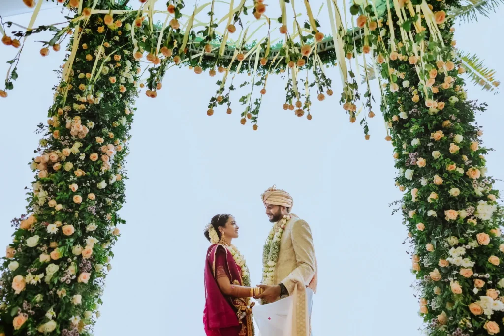 Bride and groom under floral arch"